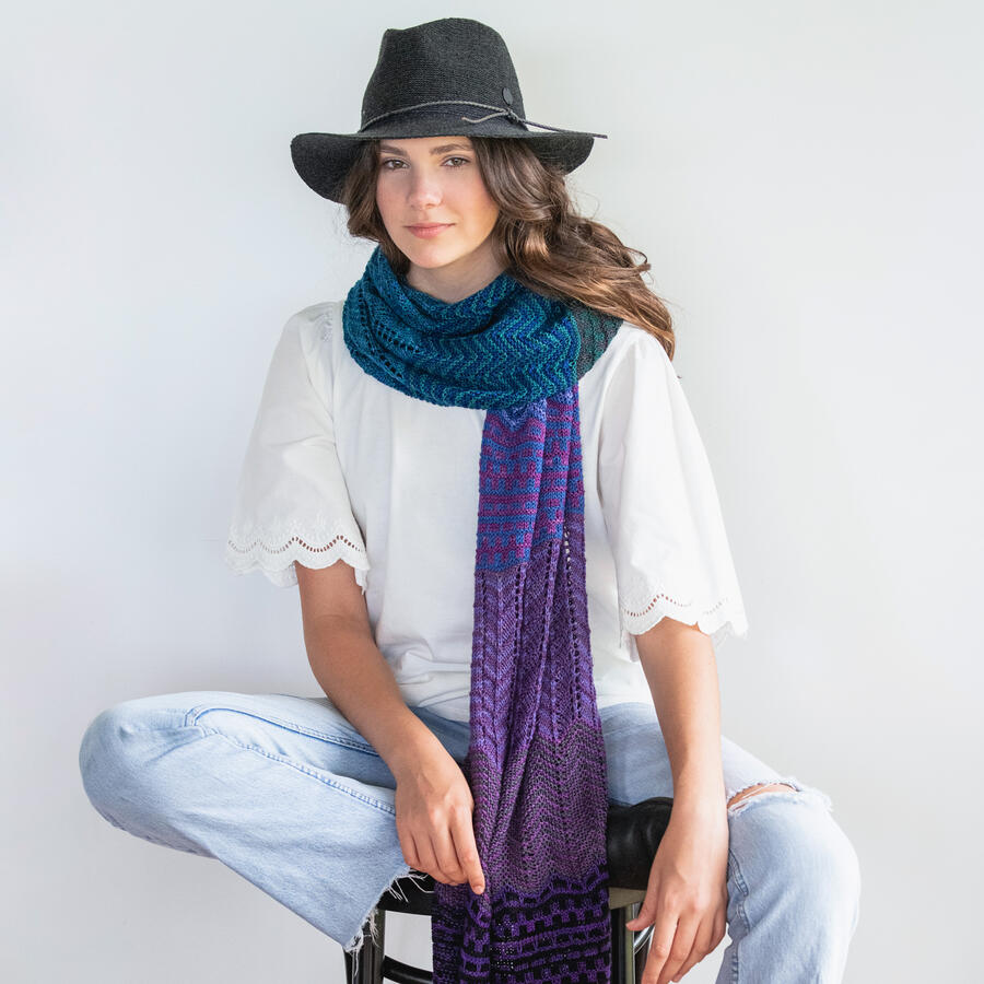 A long rectangular knitted wrap with faded slip stitch colour sections