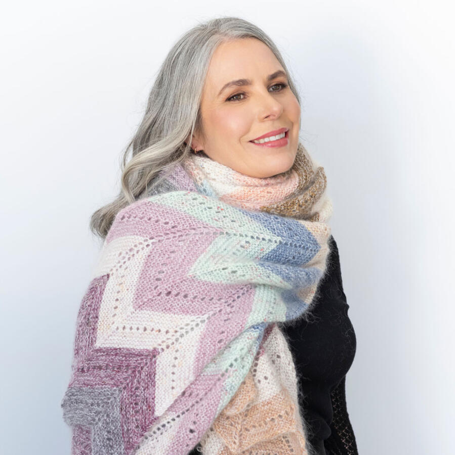 Designer Helen Stewart of Curious Handmade wears an oversized knitted wrap featuring pastel chevrons.